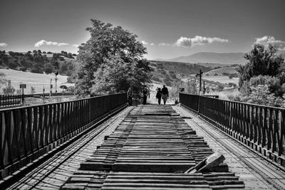 Rear view of people walking on footbridge