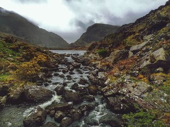 Scenic view of river amidst mountains against sky