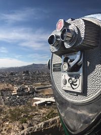 Close-up of coin-operated binoculars against mountain