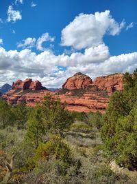 Rock formations on landscape against cloudy sky