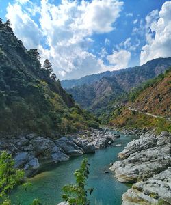 Scenic view of river amidst mountains against sky