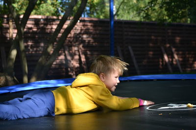 A boy on a trampoline in the garden.