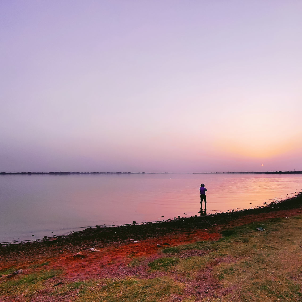 water, horizon, sky, dawn, shore, sunrise, sea, beach, morning, beauty in nature, scenics - nature, land, tranquility, nature, one person, body of water, coast, tranquil scene, horizon over water, landscape, reflection, full length, environment, lifestyles, ocean, idyllic, standing, adult, cloud, leisure activity, orange color, men, silhouette, non-urban scene, outdoors, activity, copy space, holiday, vacation, afterglow, trip, fishing, clear sky, relaxation, travel destinations, sun, coastline, travel, pink, solitude, rural scene