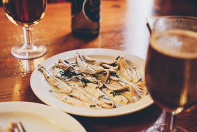 High angle view of seafood and red wine served on table