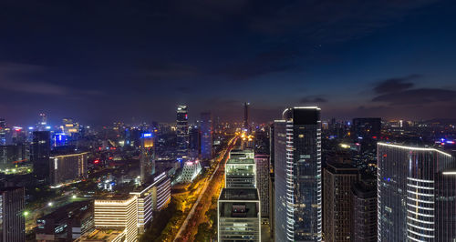 Illuminated buildings in city against sky at night