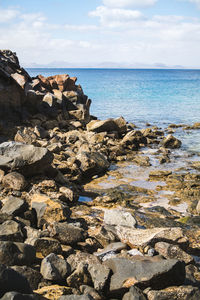 Rocks on sea shore against sky in lanzarote 