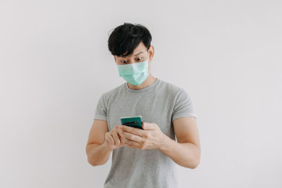 Man using smart phone against white background