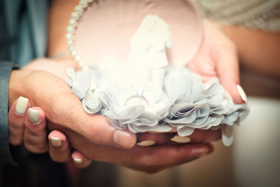 Close-up of couple holding ring during wedding ceremony
