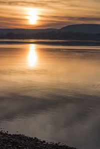 Scenic view of lake against orange sky