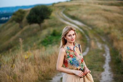 Portrait of smiling young woman standing on field