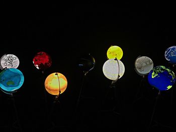 Low angle view of illuminated lanterns against sky at night