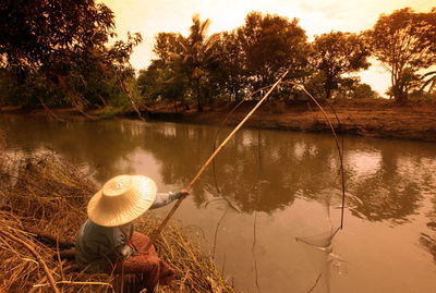 Man fishing in lake at forest