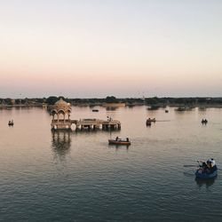 Boats in calm sea at sunset