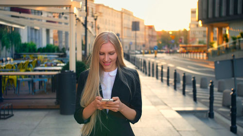 Portrait of young woman standing in city