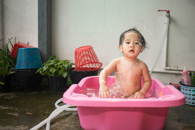 Boy sitting on wet table in bathroom at home