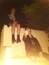 Young couple sitting on wall