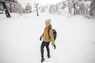 Full length of boy skiing on snow covered field