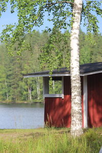 House by lake against trees