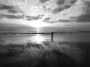 Silhouette wonan on beach against sky