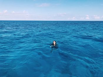 Young woman in sea against sky