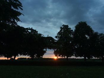 Scenic view of grassy field against cloudy sky