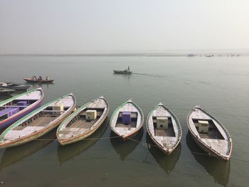 Boats moored in sea against clear sky