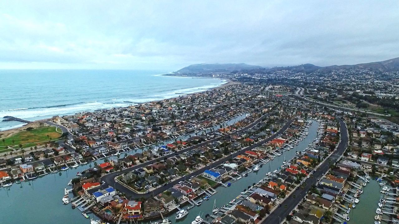 sea, water, high angle view, horizon over water, city, cityscape, architecture, sky, built structure, building exterior, aerial view, crowded, coastline, transportation, beach, residential district, city life, nautical vessel, cloud - sky, travel destinations