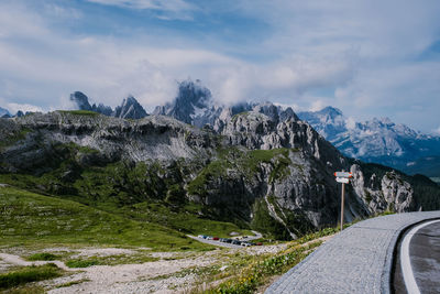 Road by mountains against sky