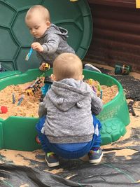 Children playing with toys and sand in yard