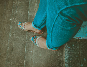 Low section of woman standing on footpath