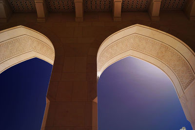 Low angle view of arch windows of historic building against clear sky