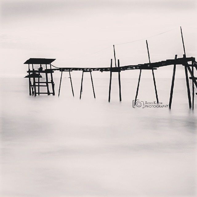 low angle view, sky, clear sky, outdoors, hanging, safety, no people, protection, day, copy space, metal, in a row, text, pole, security, communication, nature, environmental conservation, wood - material, built structure