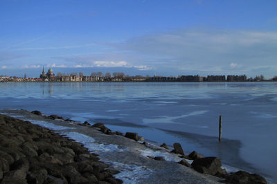 Scenic view of lake against sky during winter