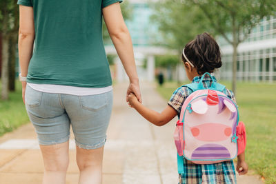 Young millennial mother sending daughter off back to school