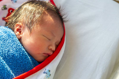 Close-up of cute boy sleeping on bed