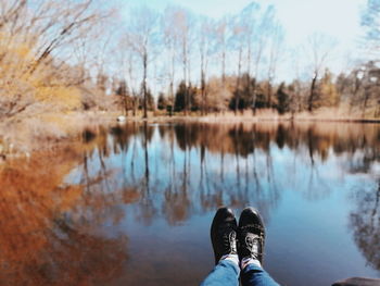 Low section of woman legs by lake