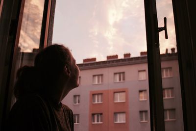 Portrait of man looking through window