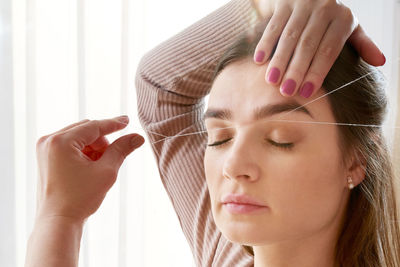 Woman threading eyebrows