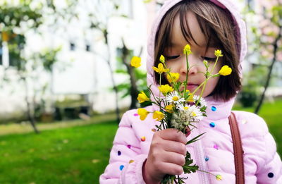 Portrait of girl holding purple flowering plant