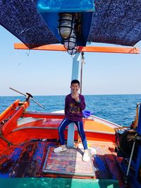 Full length of boy in boat on sea against sky