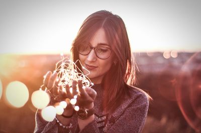 Close-up of young woman holding lights