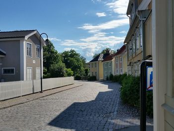 Houses by trees against sky