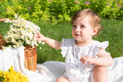 Portrait of cute baby girl picking flowers