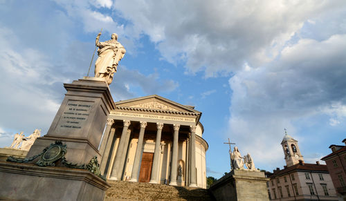 Low angle view of statues on building against sky