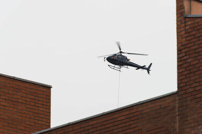 Low angle view of helicopter flying against clear sky