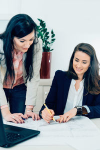 Young woman using smart phone on table