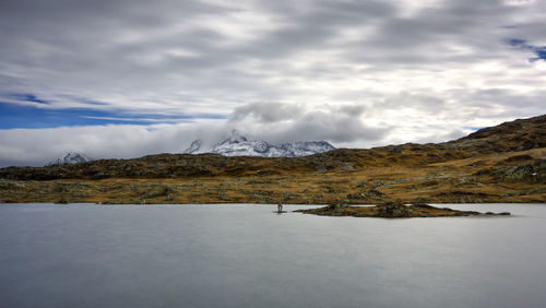 Scenic view of lake by mountains against sky