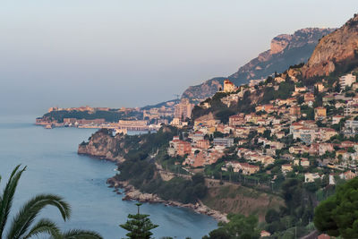 Aerial view of townscape by sea against sky