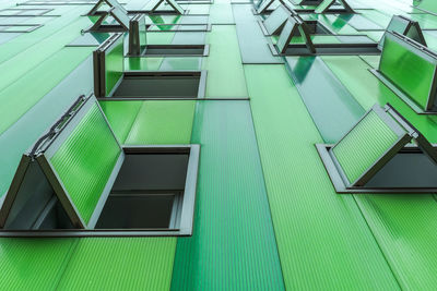 Contemporary building with vivid green facade and opened windows