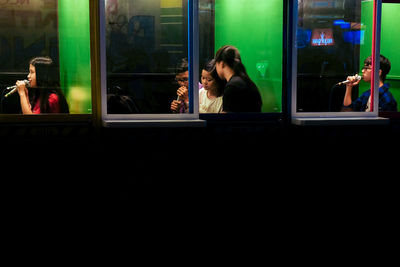 Portrait of woman seen through glass window at night